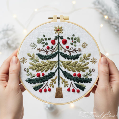 Two hands holding the Christmas tree hoop, green fir with red berries and a gold star