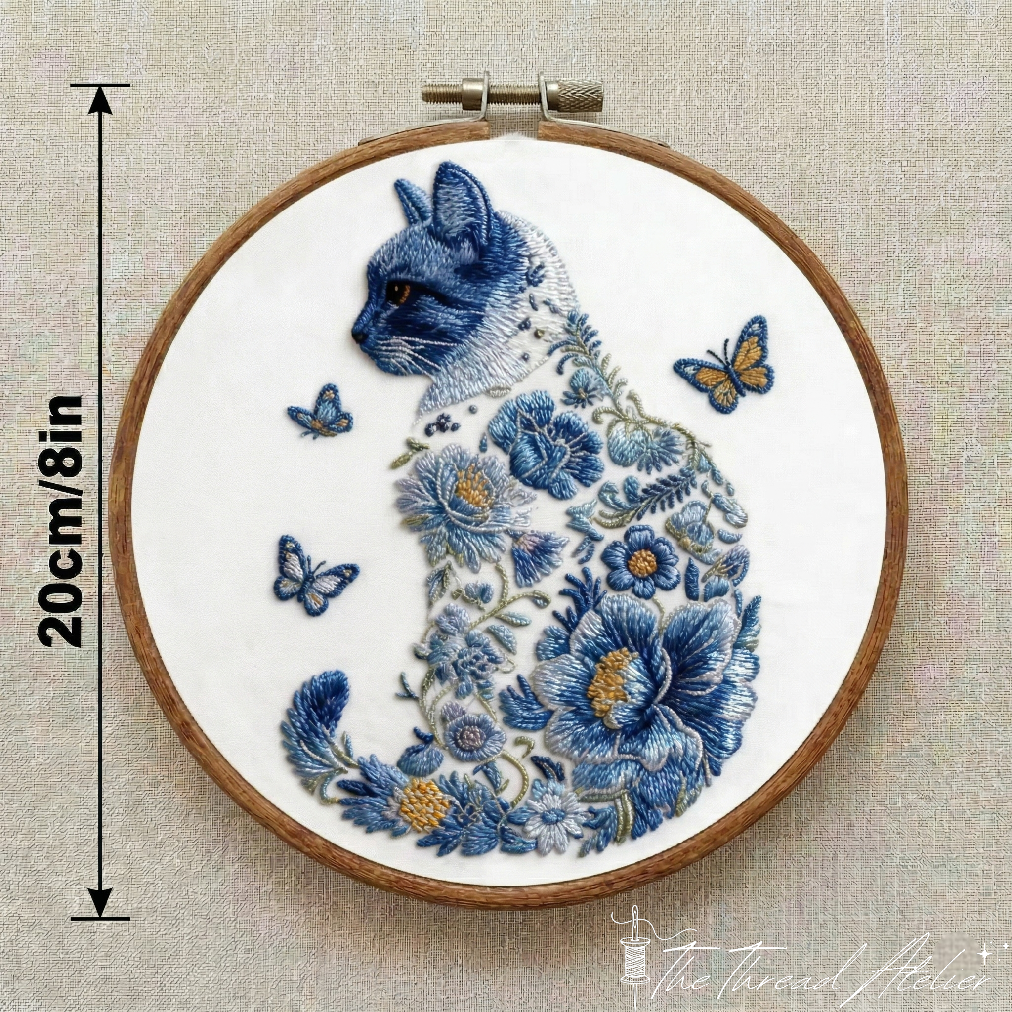 Feline embroidery design surrounded by flowers, stitched in a hoop