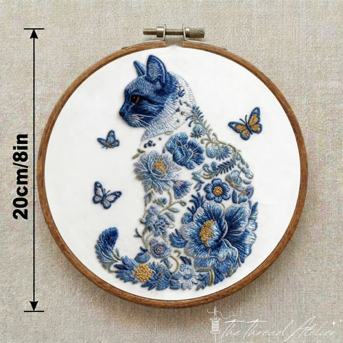 Feline embroidery design surrounded by flowers, stitched in a hoop