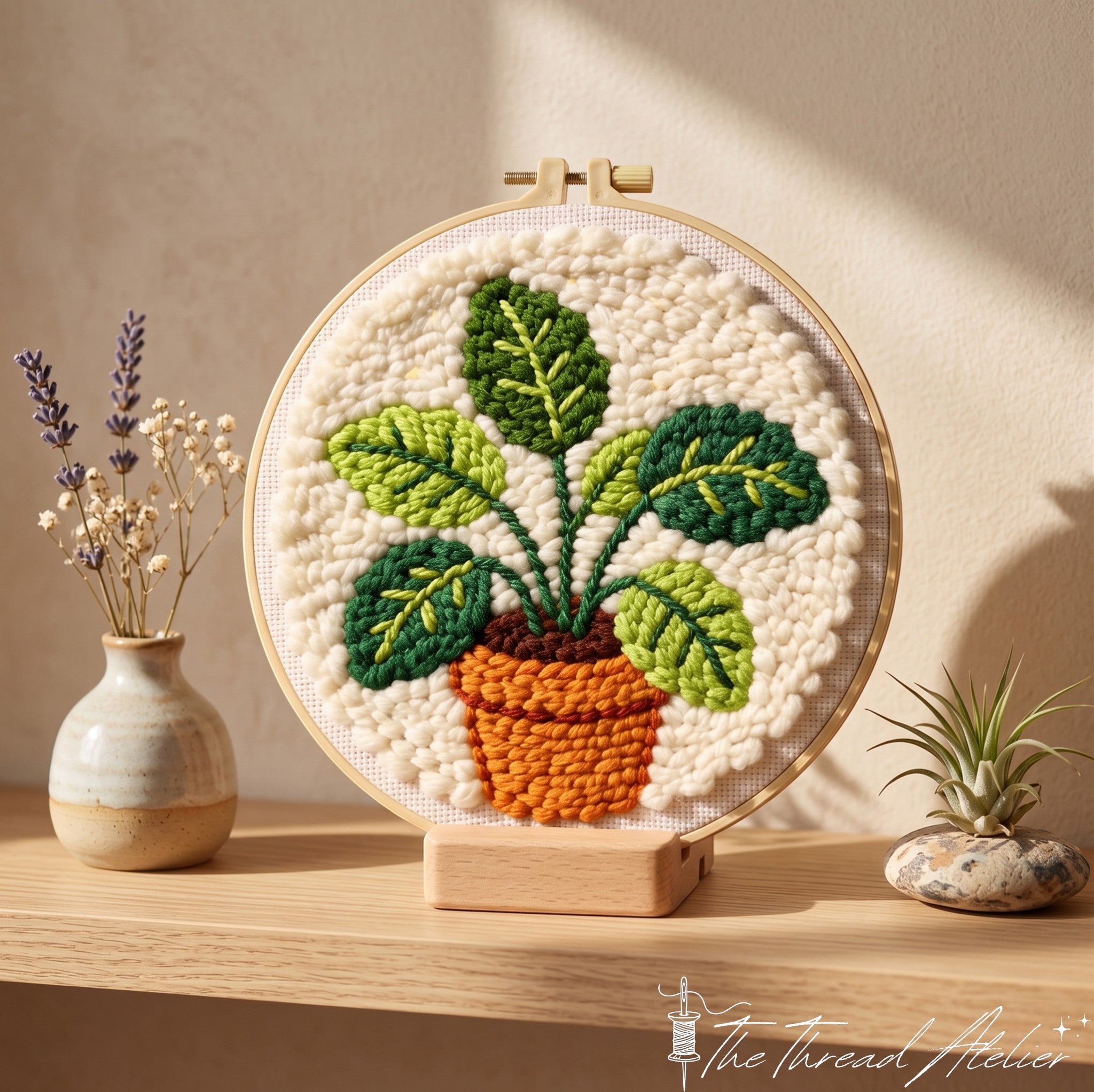 Punch needle houseplant hoop worked in green and terracotta yarn