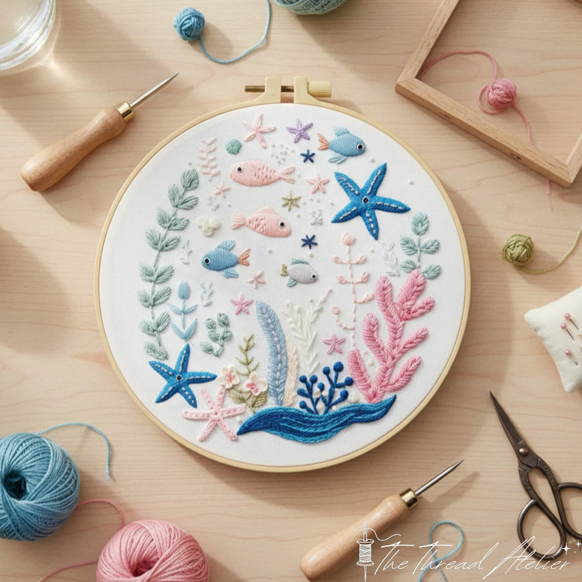 Underwater design lying on a pale table with thread balls, scissors and a pincushion